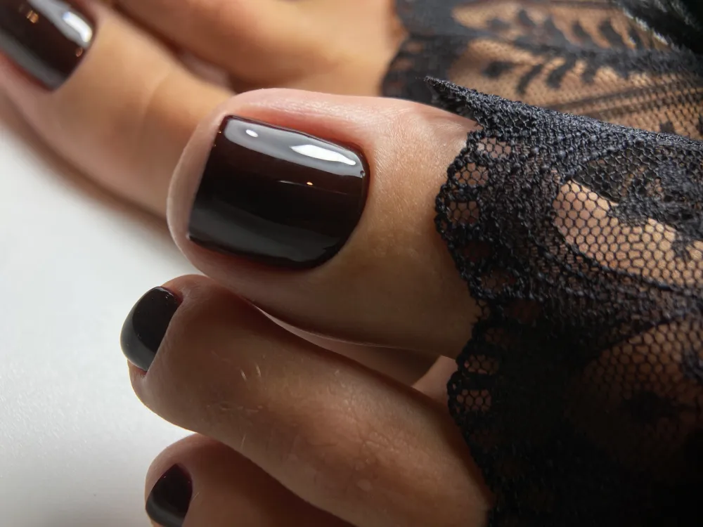 Pédicure avec vernis noir et dentelle