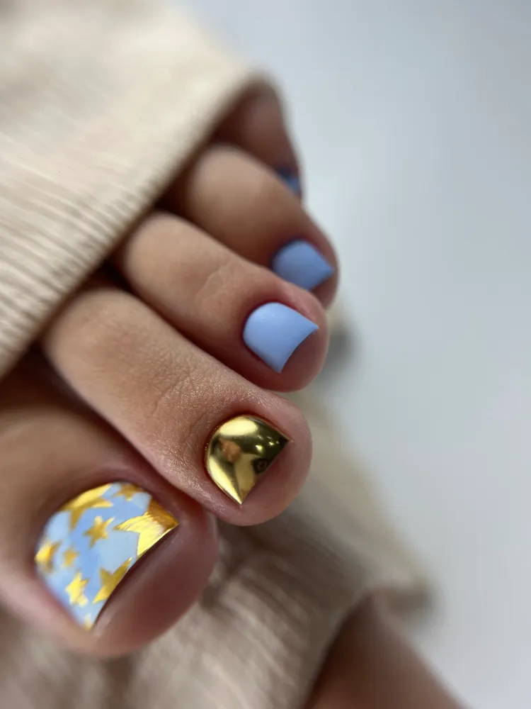 Ongles de pieds avec vernis bleu et doré