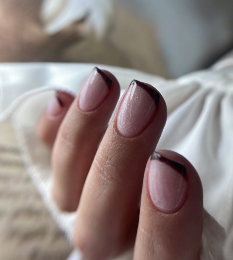 Ongles avec vernis rose et pointe noire